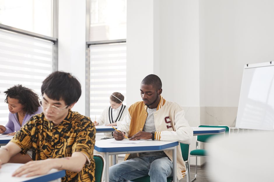 Alunos concentrados realizando uma prova em sala de aula