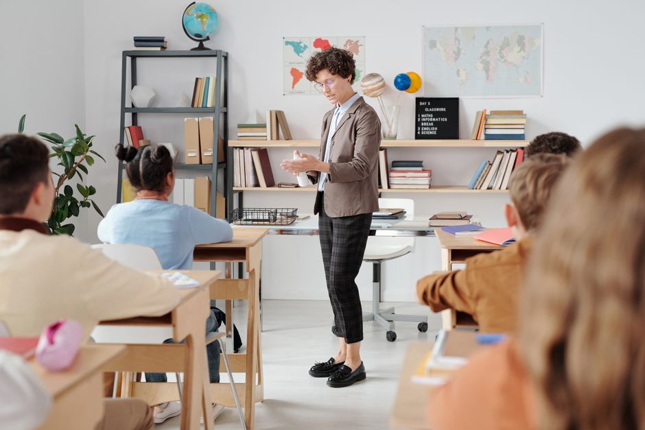 Sala de aula com alunos atentos durante a explicação da professora
